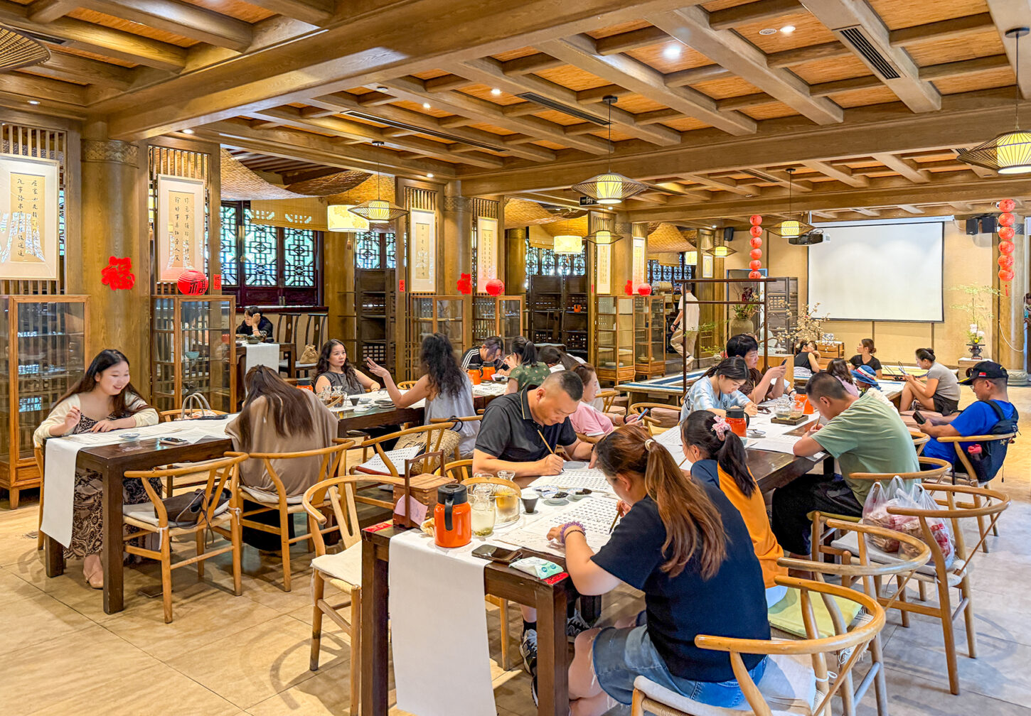 In einer klimatisierten Nebenhalle des Wenshu-Tempels in Chengdu schreiben Besucher:innen das Sutra der höchsten Weisheit, das Herz-Sutra, ab.